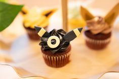 three cupcakes decorated with black and white icing are sitting on a plate