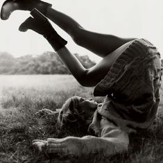 a woman laying on the ground with her legs up