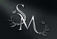 the letter m is made up of silver leaves and vines on a black background with white lettering