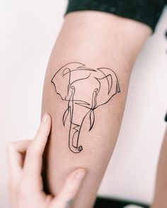 a woman's arm with an elephant tattoo on the left side of her body