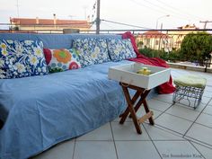 a blue couch sitting on top of a white tiled floor