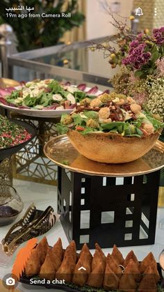 a table topped with lots of different types of food on top of plates and serving utensils