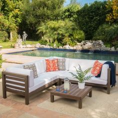 a white couch sitting on top of a wooden table next to a pool