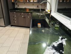 a kitchen with green marble counter tops and stainless steel appliances