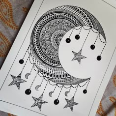 a black and white drawing of a crescent with stars hanging from it's sides