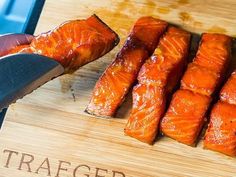 someone is slicing salmon on a cutting board