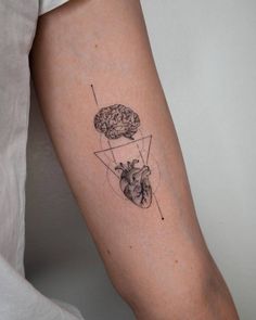 a person with a tattoo on their arm has a heart and brain in the shape of a triangle