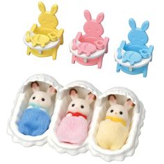 three small toy animals are in an egg shaped container with two smaller ones sitting next to each other