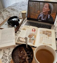 an open book sitting on top of a bed next to a cup of coffee and laptop computer