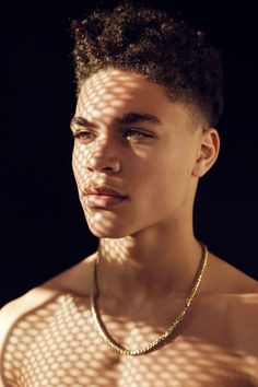 a young man wearing a gold chain necklace