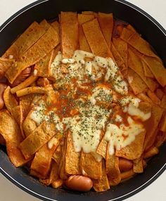 a skillet filled with nachos and cheese on top of eachother