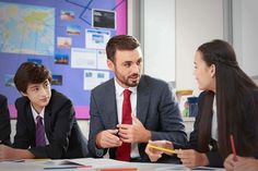 a group of people sitting around a table with papers and pencils in front of them