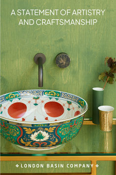 a bowl shaped sink sitting on top of a wooden table next to a green wall