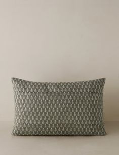 a gray and white pillow sitting on top of a table