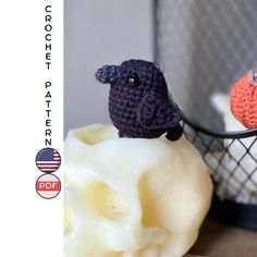 two crocheted sheep figurines sitting next to each other on a table