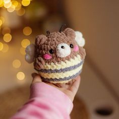 a hand holding a small crocheted stuffed animal in it's right hand