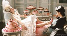 two women sitting in chairs with cakes on the table