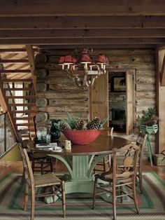 a dining room table with chairs and a red bowl on top of it in front of a spiral staircase