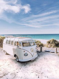 an old vw bus parked on the beach