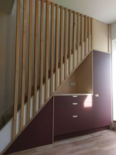 an empty room with wooden stairs and drawers