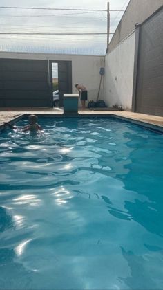 a man is swimming in a pool with blue water