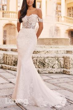 a woman in a wedding dress posing for the camera with her hands on her hips