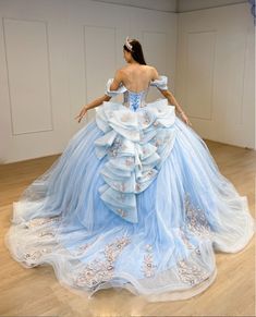 Turn your quinceanera into a magical celebration with this stunning Sky Blue Off-the-Shoulder Quinceañera Dress. This dress features a regal ball gown silhouette and flows gracefully into a dramatic chapel train, making every step feel like a fairy tale moment. The delicate off-the-shoulder neckline highlights your shoulders with elegance, while the sleeveless design ensures comfort throughout your special day. It is made from soft tulle fabric and is adorned with intricate appliques and shimmer Light Blue With Gold Quinceanera Dresses, Sweet 15 Dresses Quinceanera Light Blue, Blue And White Quinceanera Dresses, Sweet 15 Dresses Quinceanera, Dresses With Bows, Light Blue Quinceanera Dresses, Baby Blue Quinceanera, Cinderella Quinceanera Themes, Dreamy Sky