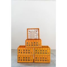 three orange boxes stacked on top of each other in front of a white wall and floor