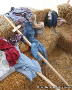 clothes and other items are piled up on hay bales in the background is a cross