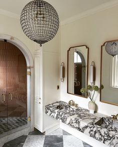 a bathroom with marble counter tops and two mirrors on the wall next to each other