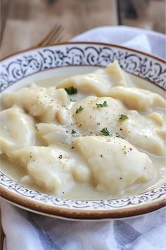 a white plate topped with dumplings covered in gravy