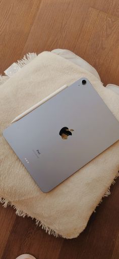 an apple ipad sitting on top of a white blanket