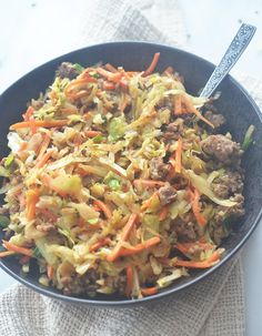 a bowl filled with meat and veggies on top of a white table cloth