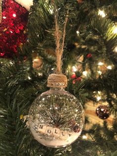 a glass ornament hanging from a christmas tree with the word holly written on it