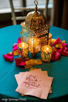 a table topped with a lit candle and napkins