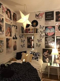 a bed room with a neatly made bed and lots of pictures on the wall above it