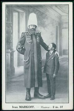 an old black and white photo of a man in uniform standing next to a young boy