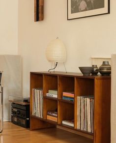 a living room with a book shelf filled with books and vinyl record's on top of it