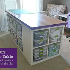 a craft table with plastic bins on it in the middle of a living room