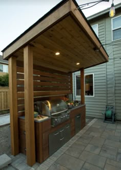 an outdoor kitchen area with grill, sink and bbq in the middle of it