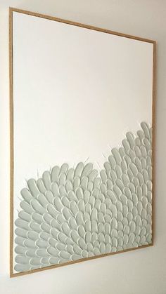 a large white painting hanging on the side of a wall