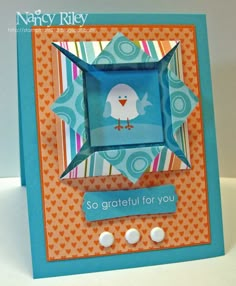 a close up of a greeting card with buttons on the bottom and an origami bird