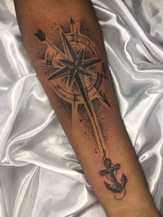 an anchor and compass tattoo on the arm