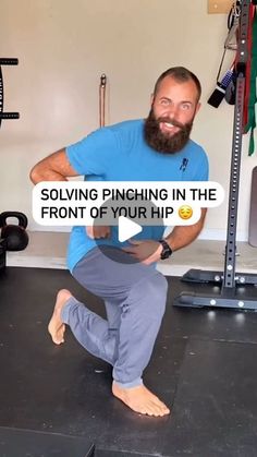 a man with a beard is doing squats in front of a gym equipment rack