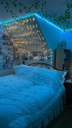 an unmade bed in a room with lights on the ceiling and pictures above it