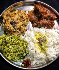 a metal plate topped with rice and different types of food