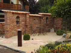 a brick building with a small garden in the front and side yard area next to it