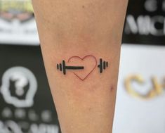 a heart and barbells tattoo on the leg