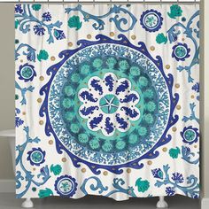 a blue and white shower curtain with an ornate design on the front, hanging from a metal rod