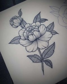 a black and white flower tattoo design on the back of a woman's shoulder